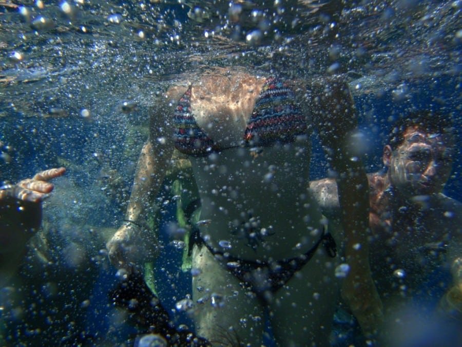 A group of people enjoying the crystal-clear waters of Croatia's national parks, dressed in colorful bikinis.