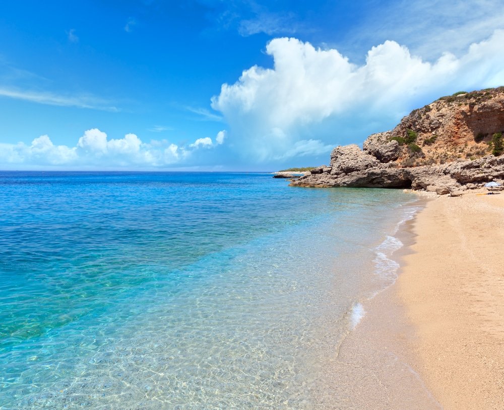 One of the best beaches in Albania, this sandy beach boasts clear blue water. Drymades beach, Albania. Summer Ionian sea coast view. Blue sky with some cumulus clouds.