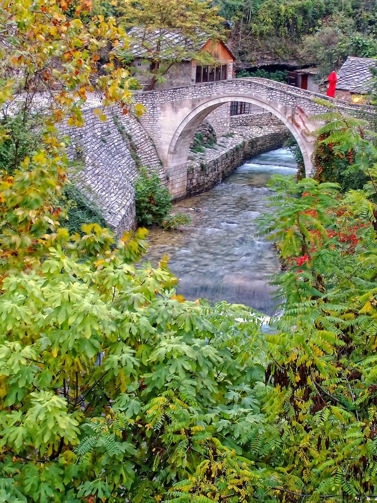 One of the things to do in Mostar, Bosnia and Herzegovina is to visit the iconic crooked bridge over a river in this charming village.
