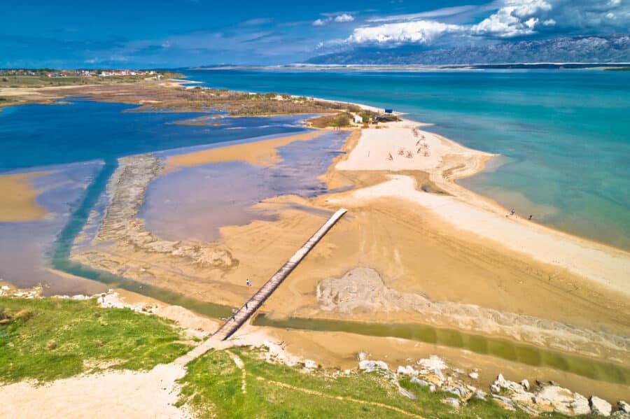 A breathtaking aerial view of a beach with glistening sand and crystal-clear water, showcasing the serenity and beauty of things to do in Nin.