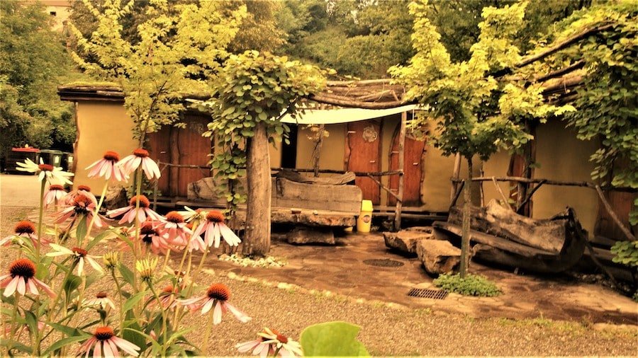 A wooden glamping house with flowers in front of it in Slovenia.